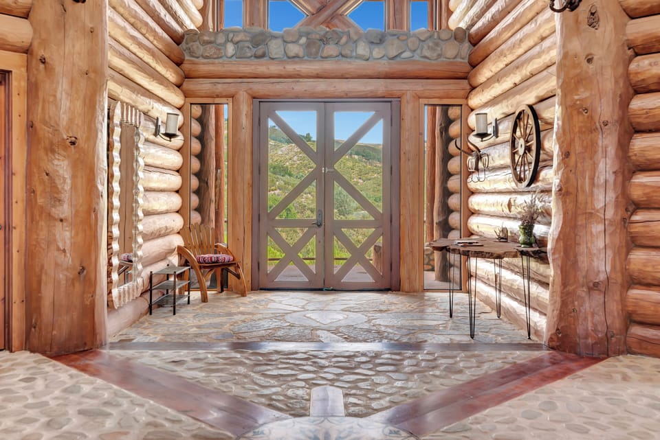 Grand entrance with timber columns and authentic log architecture