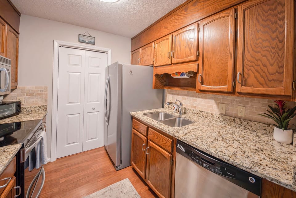 Kitchen has microwave, dishwasher, large refrigerator, and electric stove
