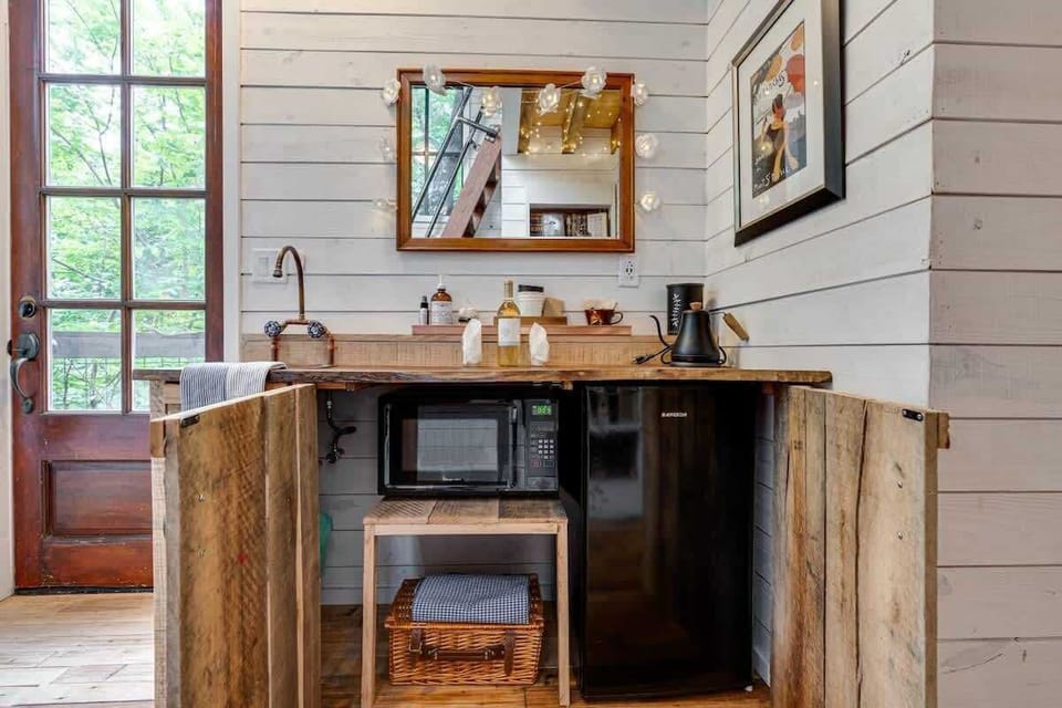 The microwave, mini fridge, and a picnic basket are inside the cabinets
