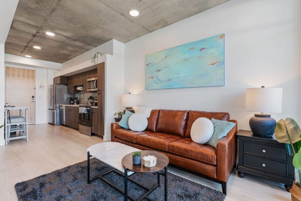 Beautifully designed living room. 65" TV, leather sofa and amazing views of mountains and city skyline.