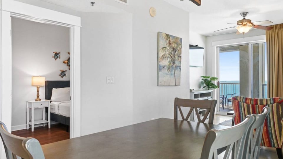 Your spacious dining room flows beautifully into the bedroom, with ocean views and tropical artwork creating a serene coastal atmosphere.