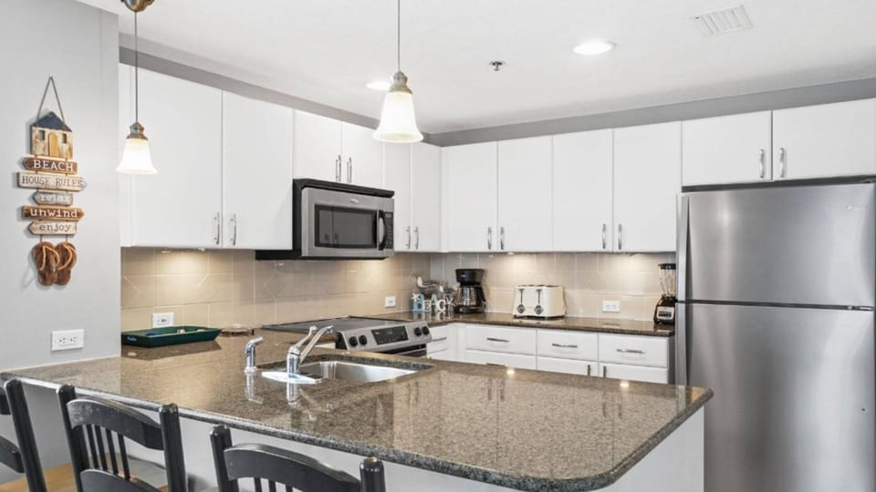 Your modern kitchen awaits with gleaming granite counters, stainless appliances, and everything needed to create memorable meals during your stay.