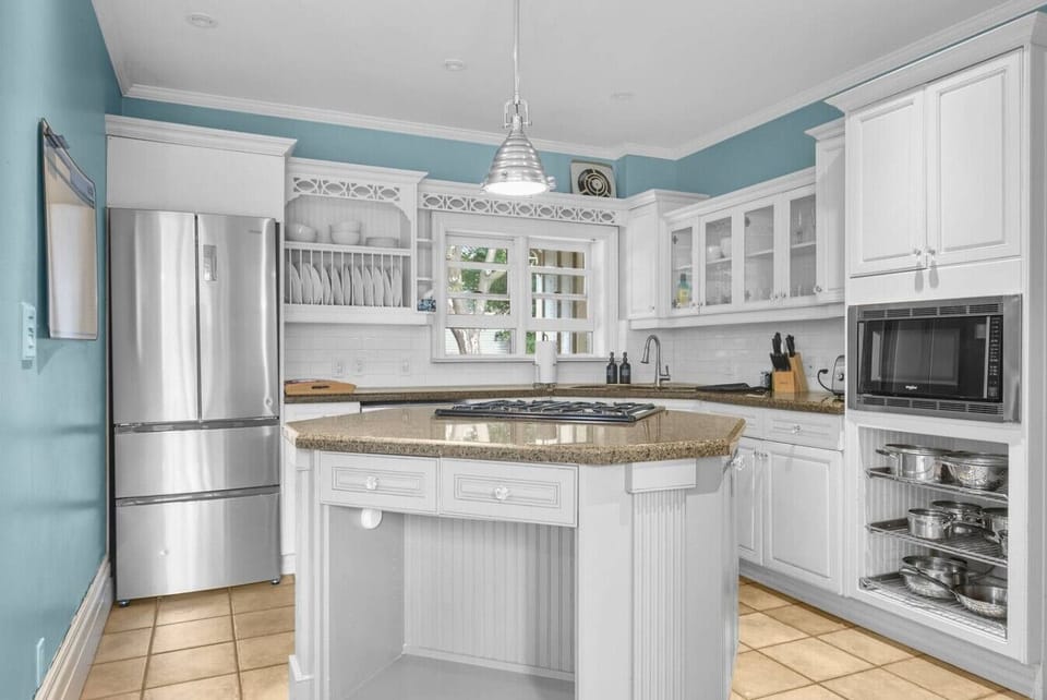 The bright, open kitchen is a chef`s dream. With an island gas stove, modern appliances, and a beautiful blue backsplash, you`ll feel right at home cooking up a delicious meal. It`s the perfect spot to gather.