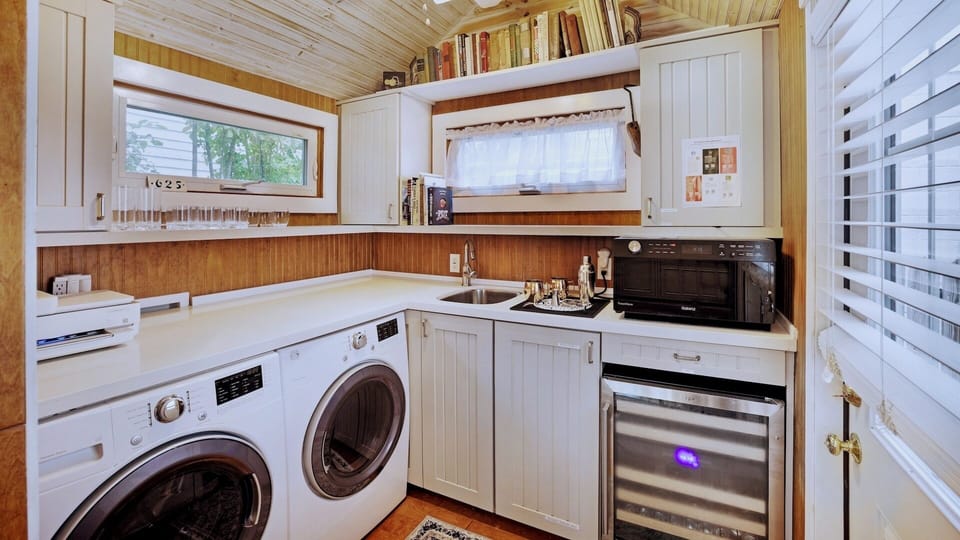 The pantry extends from the kitchen and is complete with a washer, dryer, microwave, and wine chiller...