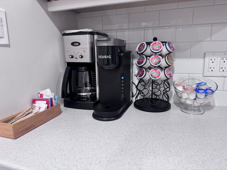 Coffee & tea station: drip, K-cups, teas, creamers, sugar & honey. Grounds above