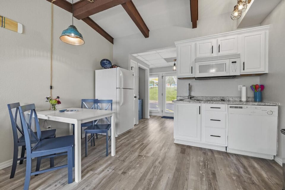 Kitchenette with 2 burner cooktop, full fridge, dishwasher, and a crockpot.
