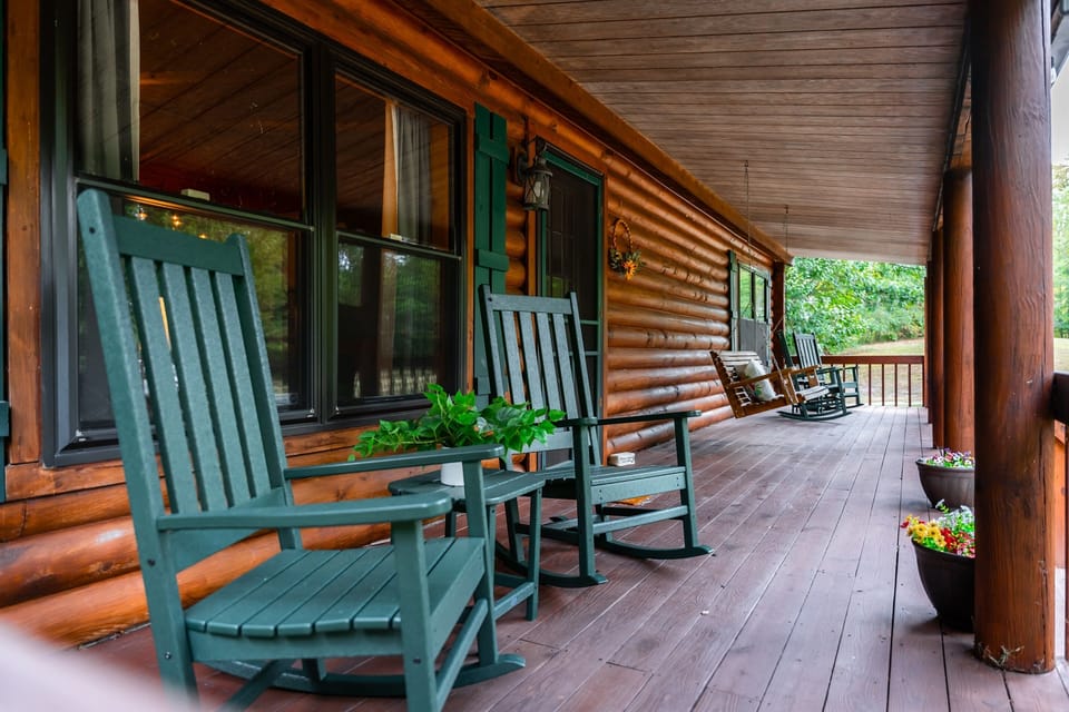 Rocking chairs, swing chair, and a view of the surrounding woods
