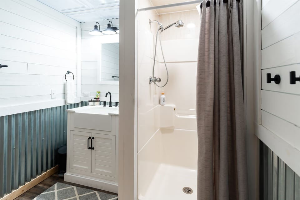 Refresh and rejuvenate in our basement bathroom with a spacious walk-in shower, stylish fixtures, and a cozy rug