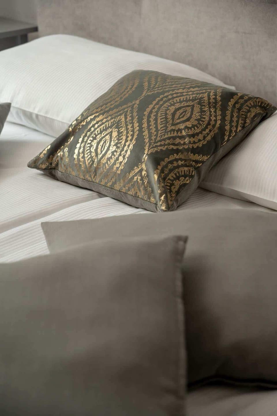 Cozy detail shot of the second bedroom showing decorative pillows and soft textures.