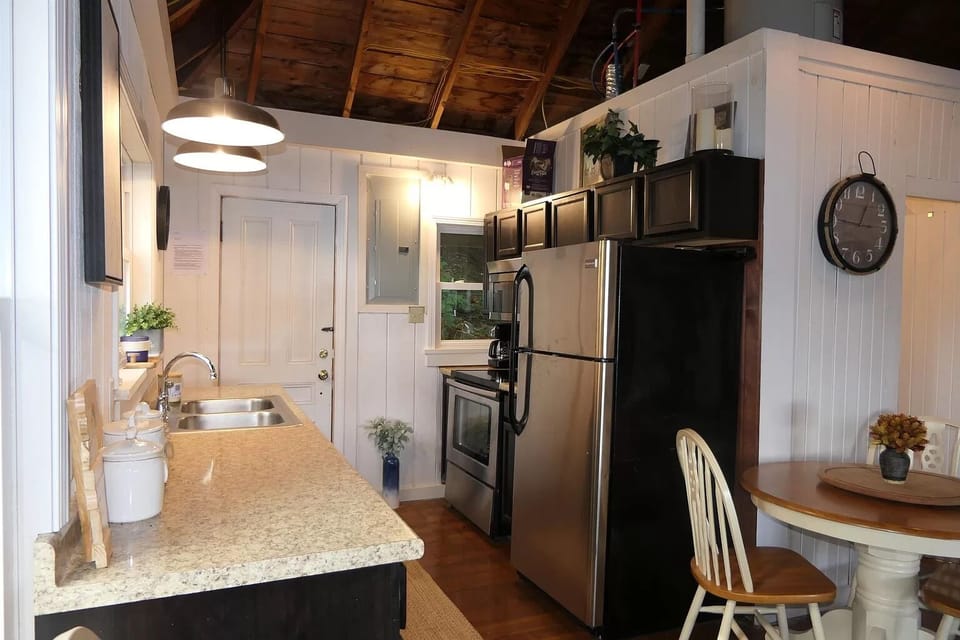Full kitchen with all necessary cooking implements and dishware.