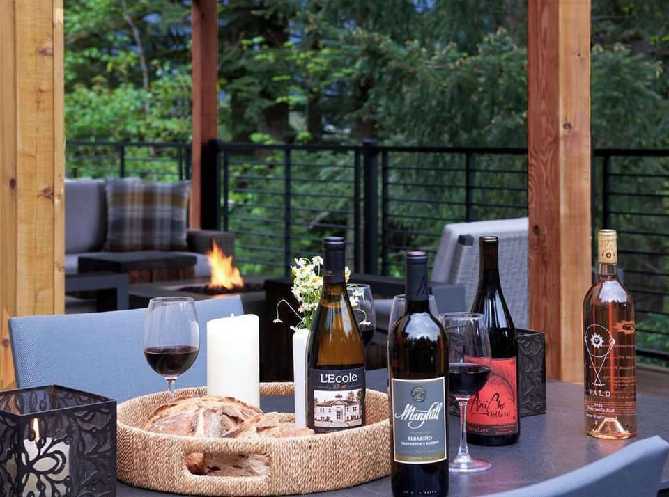 Enjoy outdoor dining on the deck with a beautiful forest backdrop and cozy ambiance.
