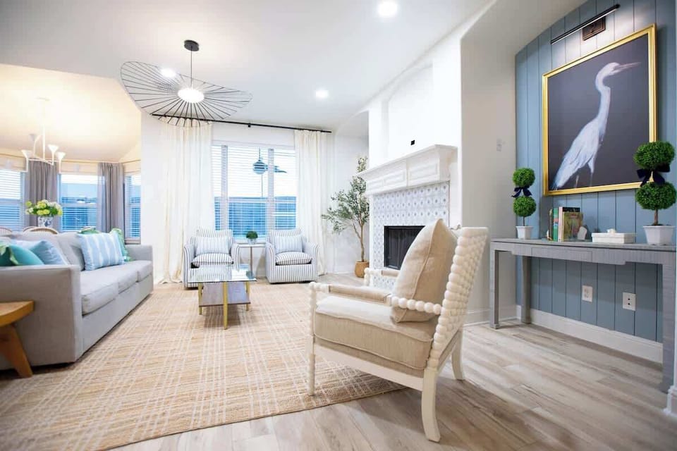 Step into a haven of relaxation in a beautifully designed living room, featuring a spacious 3-seater sofa, three sophisticated accent chairs, and a stunning pool view that embodies the perfect blend of coastal charm.