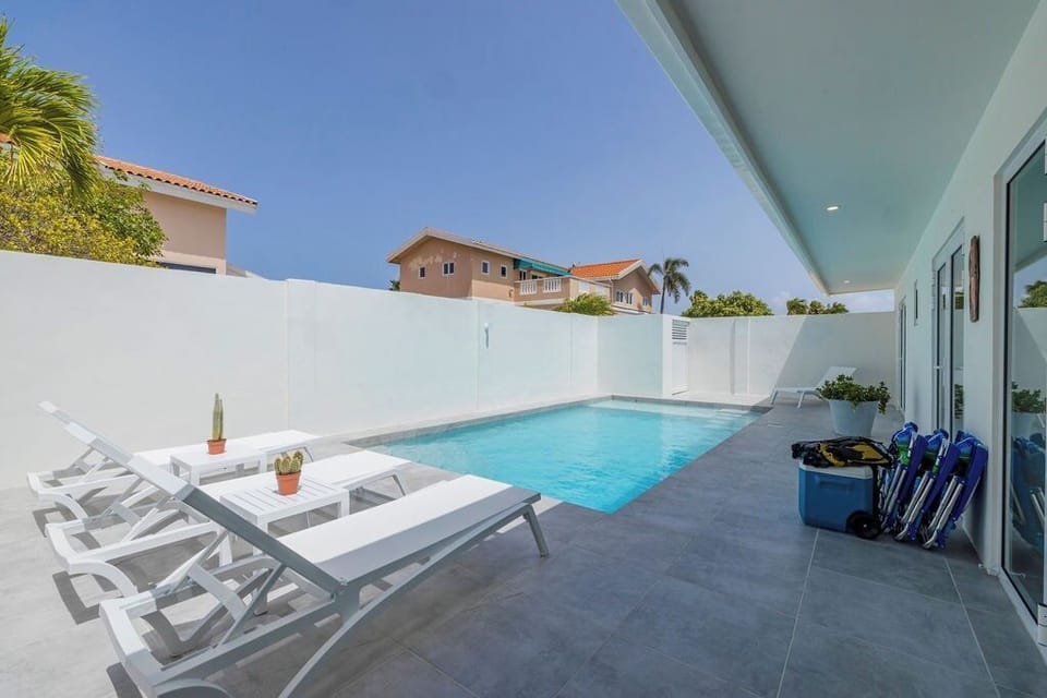 A crystal-clear private pool glistens under the warm rays of the sun with Comfortable lounge chairs line the deck, offering a perfect spot to relax and soak up the sun. The tranquil ambiance invites guests to unwind and enjoy the peaceful oasis.