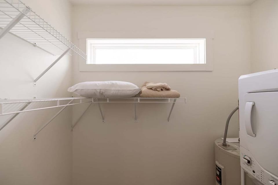 Spacious walk-in closet with in-unit washer and dryer, offering convenience for longer stays and extended visits.