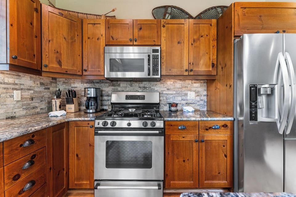 Full-size kitchen with granite countertops and stainless steel appliances.