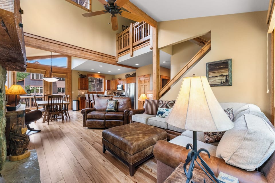 Spacious living area with vaulted ceiling, gas fireplace with stone surround, flat screen TV and access to the back patio.