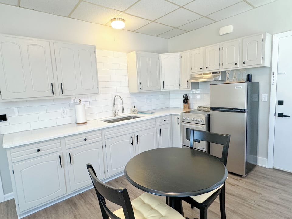 New quartz countertop with tiled backsplash and stainless steel appliances