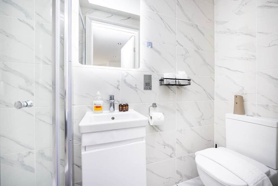 Modern marble bathrooms feature sleek white vanities, large mirrors, and chrome fixtures. Amenities include integrated shaver sockets, complimentary toiletries, and fresh towels.