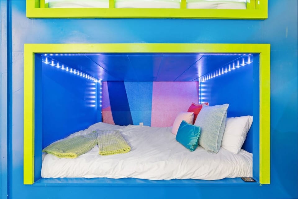 A fun bedroom with 4 queen bunk beds, slide, air hockey and climbing wall and a TV—perfect for relaxing after a day of adventure! | The Juniper, Brian Head, Utah | Voyax Luxury Vacation Rentals