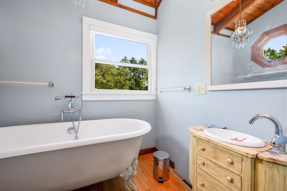 Upper level Bathroom #2 offers a dramatic chandelier and large soaking tub to bathe in