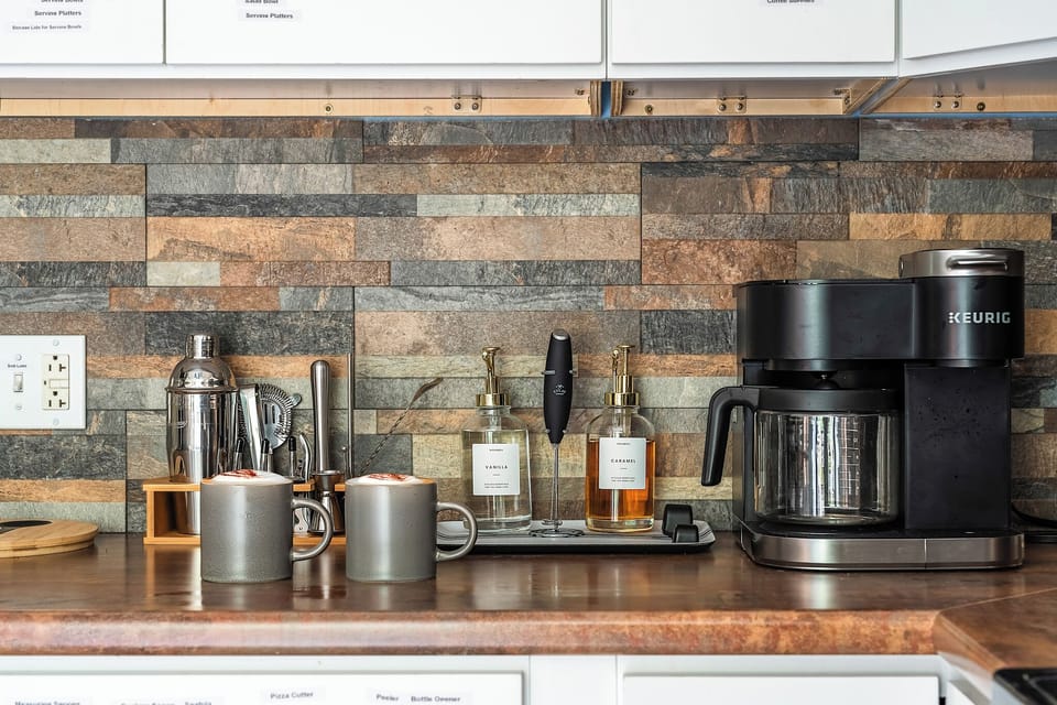 Coffee Bar Goals Wake up and caffeinate like a pro! Whether you're team Keurig or classic drip, this fully stocked station has all the fixings—frother, syrups, mugs, and even cocktail tools for that espresso martini moment. Morning routines just got an u