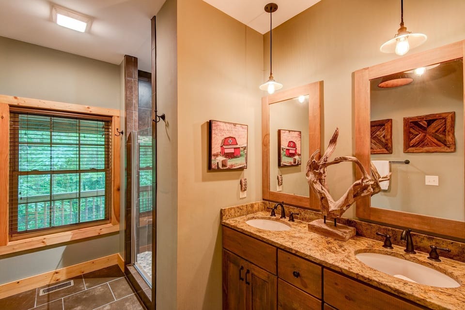 Double sinks, warm wood accents, and a walk-in shower make this bath at Beech Creek Cabin feel like a true retreat.