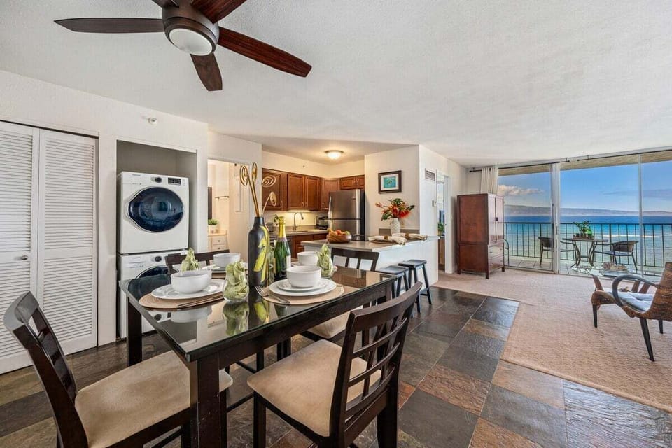 Share meals in a dining nook beside the kitchen, with sliding doors opening to the sea beyond.