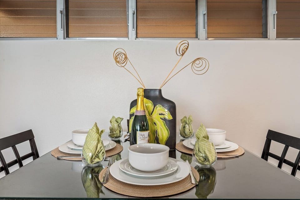 Share meals at a modern dining table set with elegant place settings and a vibrant centerpiece…