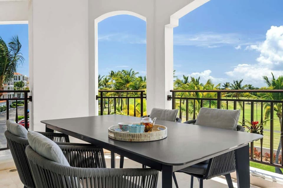 This spacious balcony is a great outdoor spot with a table for four, comfy chairs, and amazing views of the golf course and palm trees. The modern furniture and greenery make it perfect for meals or just soaking in the scenery.






