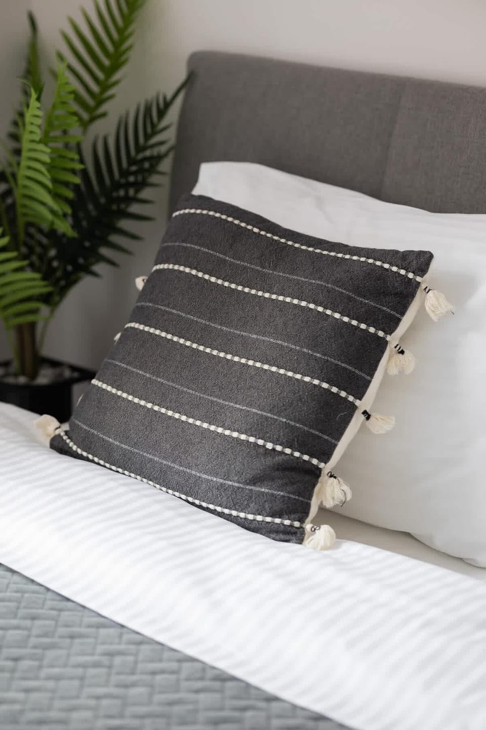 Carefully selected textiles and decorative cushions add warmth and cosiness to the bedroom.