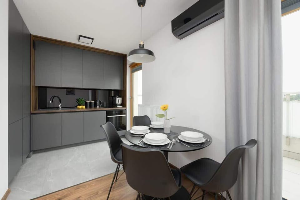 A modern kitchen with a dining area offers space for shared meals in an elegant, minimalist style.
