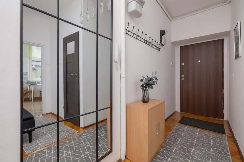 A spacious hall with a coat rack and chest of drawers welcomes guests with a warm, homely atmosphere.