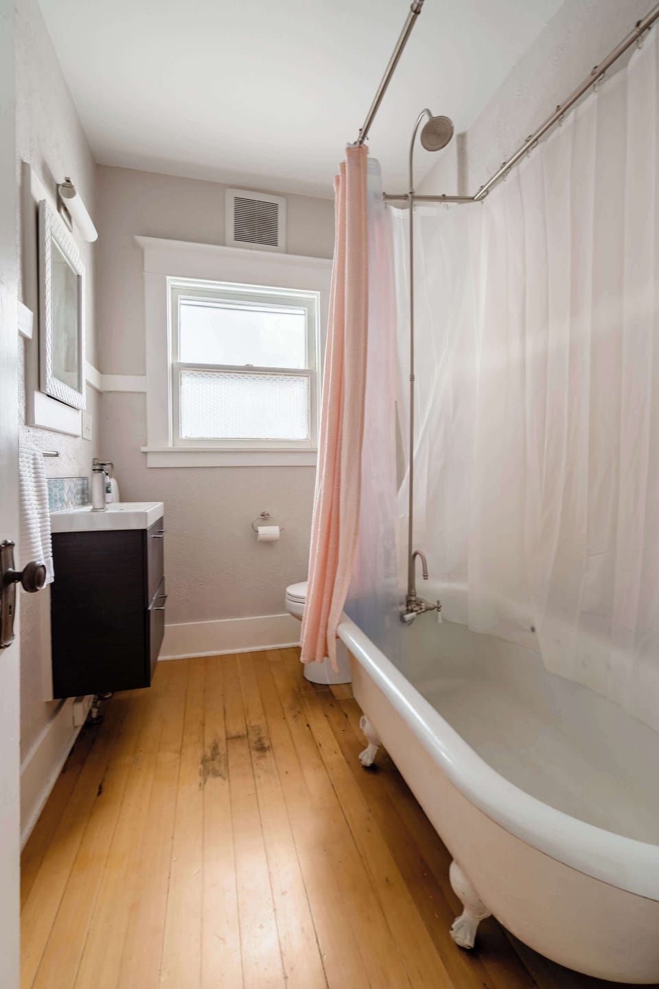 Clawfoot bathtub with shower and curtain.