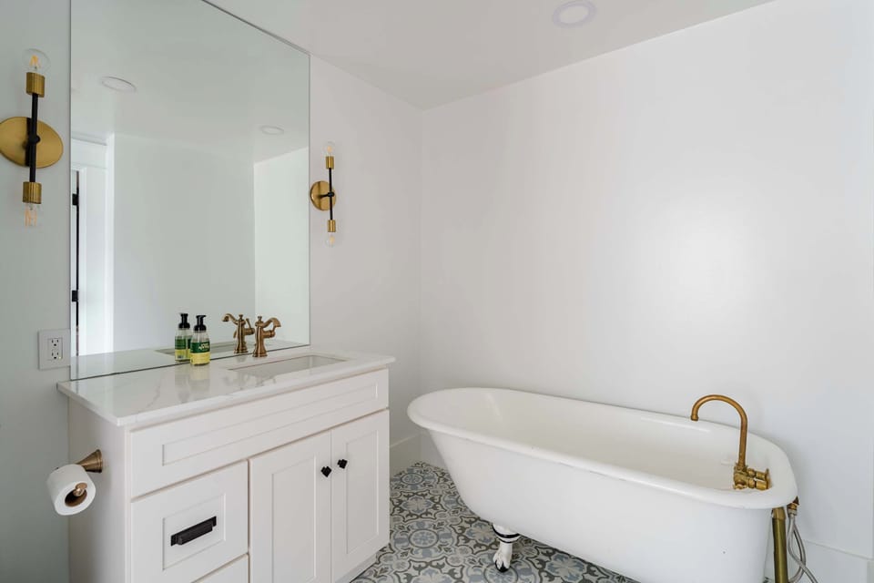 Bathroom with a freestanding bathtub and white vanity.