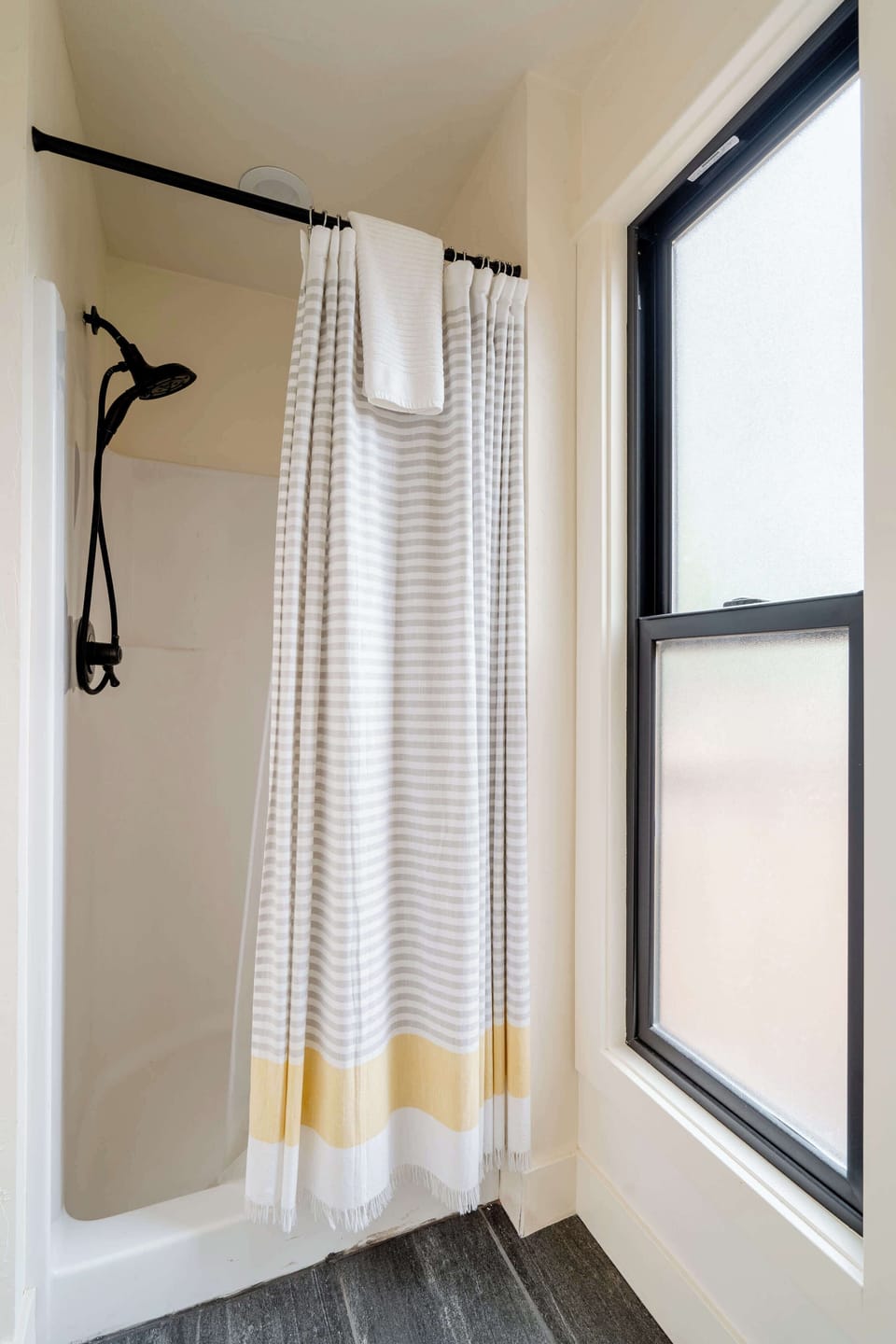 Bathtub with shower curtain and overhead shower fixture.