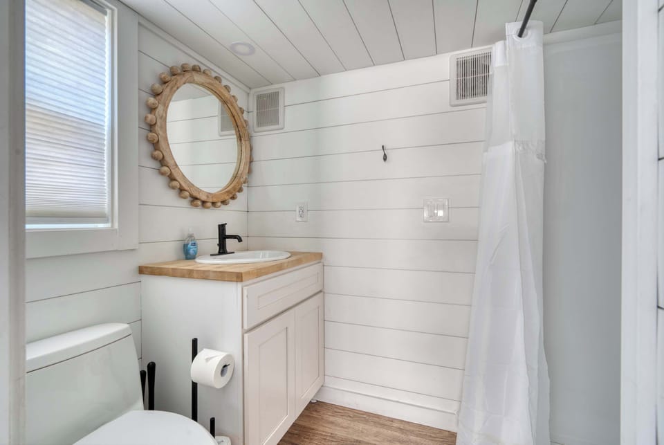 Bathroom with vanity, toilet, and shower curtain.