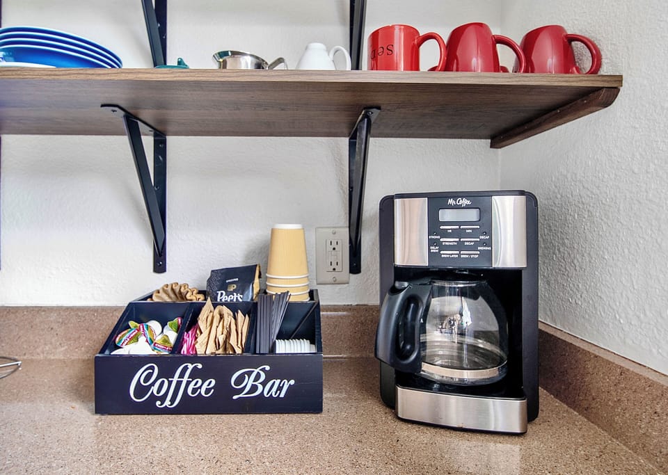 Enjoy our coffeemaker and coffee bar, featuring quality coffee and condiments.