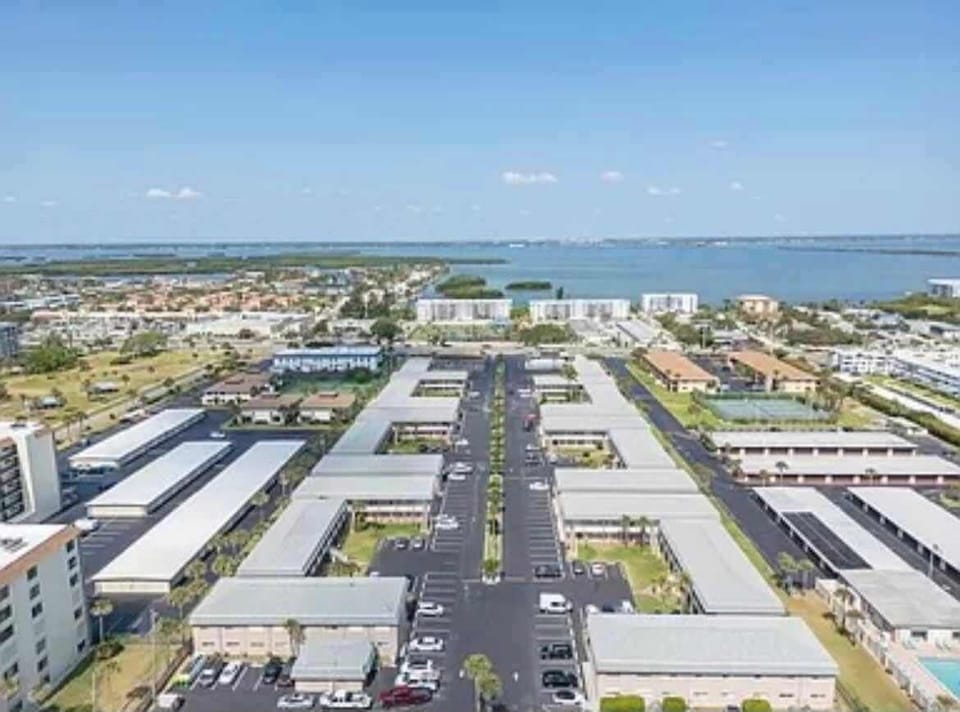 Aerial view of a waterfront community with covered parking and clear blue skies.