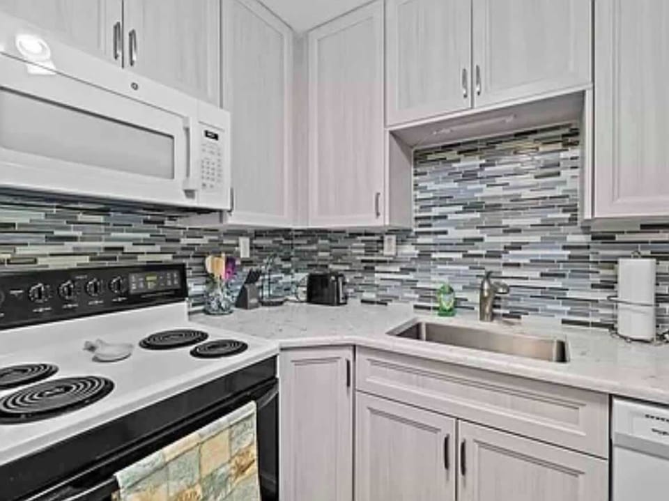 Modern kitchen with a mosaic tile backsplash and white appliances