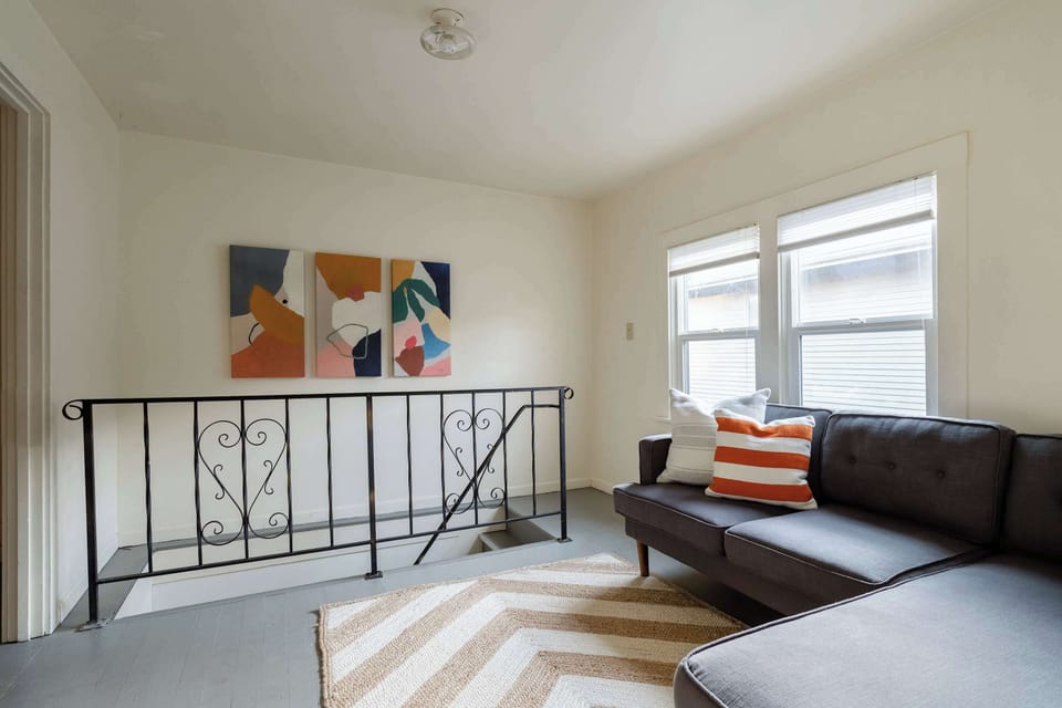 Gray sofa beside the metal stair railing.
