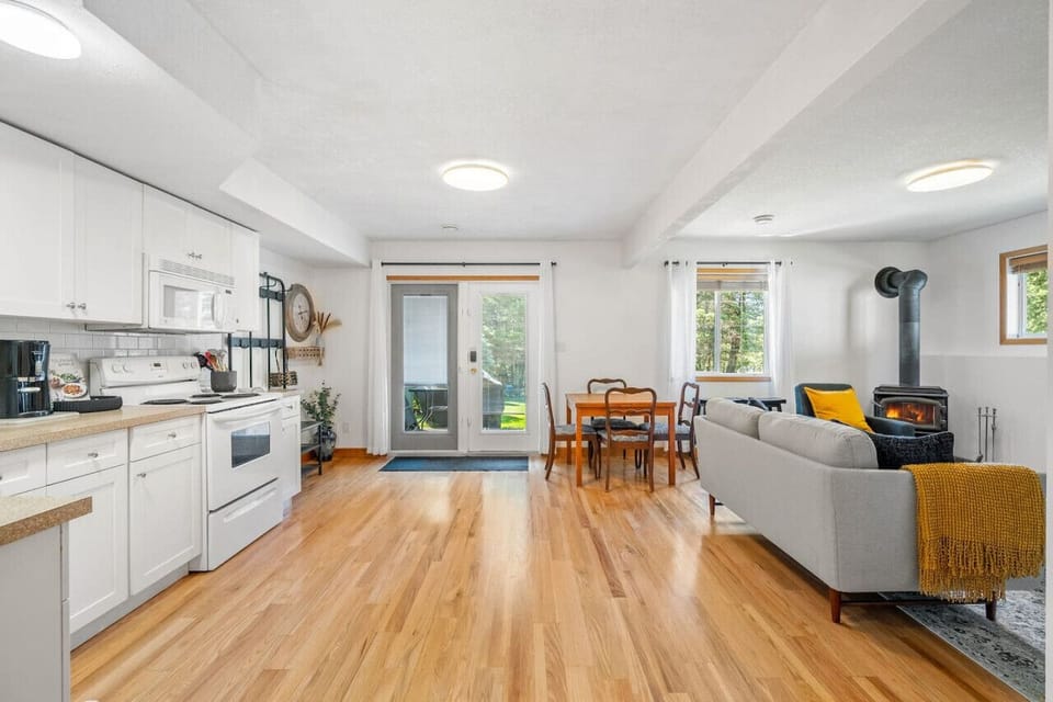 Living room with cozy seating, a Smart TV, wood-burning fireplace & board games.