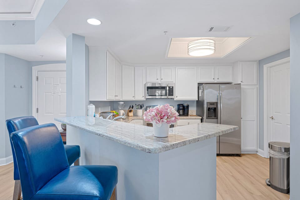This open-concept dining and kitchen area is bright, welcoming, and designed for easy coastal living.