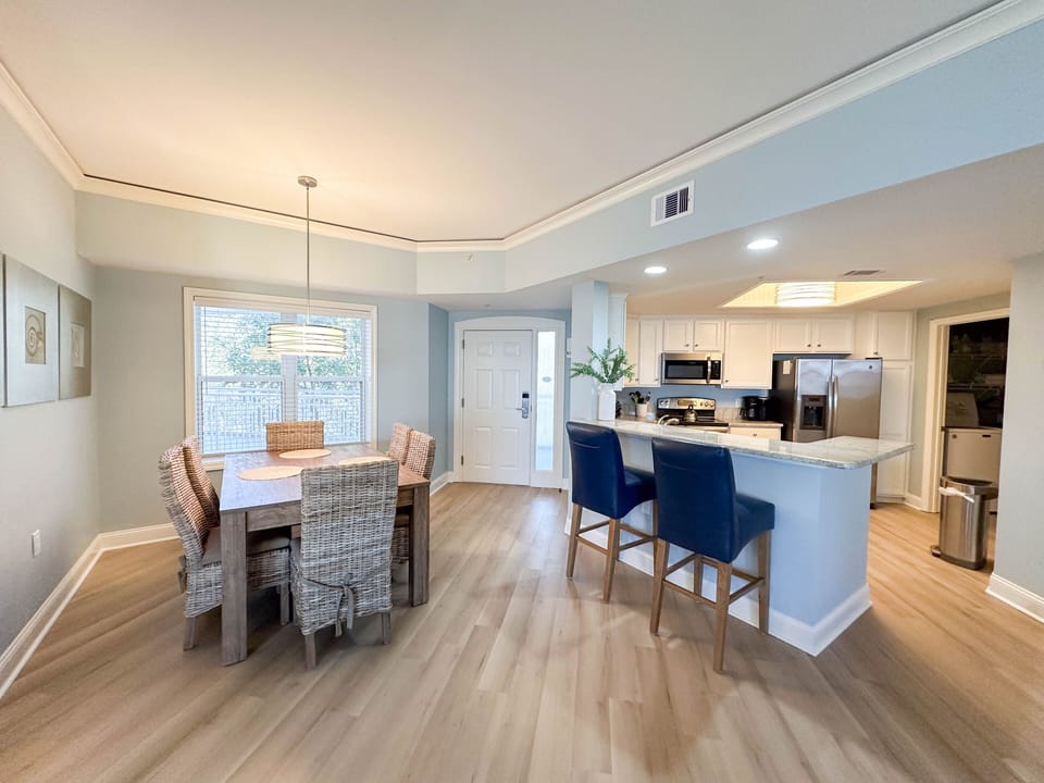 This open-concept dining and kitchen area is bright, welcoming, and designed for easy coastal living.