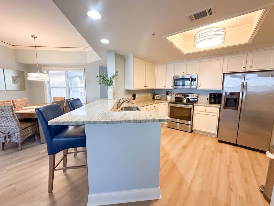 The dining space comfortably seats six, and the adjacent generous breakfast bar with seating for casual meals.