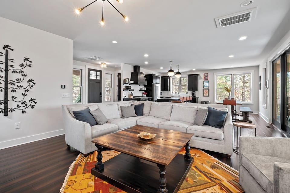 Open concept main floor with living room, kitchen, and dining area with access to the back deck