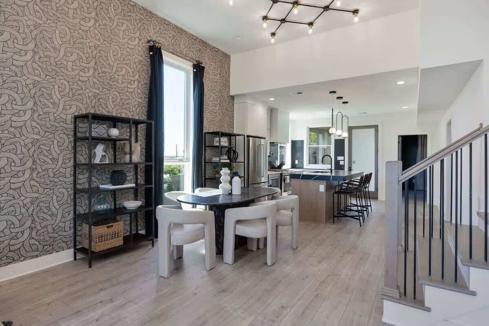 Upper Unit - 1st Floor: Open-concept living space seamlessly flows the living room, dining area, and kitchen into one. The dining table comfortably accommodates up to six guests.