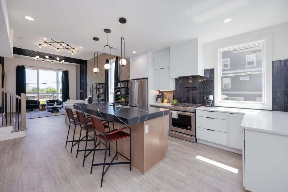 Upper Unit - 1st Floor: The fully equipped kitchen is stocked with all culinary essentials and boasts brand-new stainless-steel appliances with an oversized kitchen island offering bar seating.