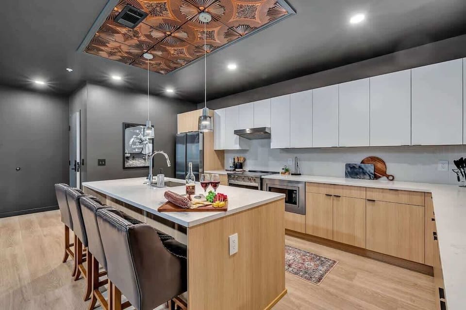 Unit 2: The fully equipped modern kitchen features culinary essentials, stainless steel appliances, and island bar seating.