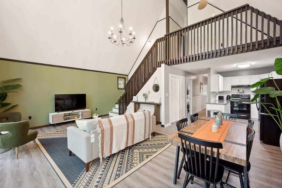 Open-concept living and dining area with vaulted ceilings and modern kitchen.