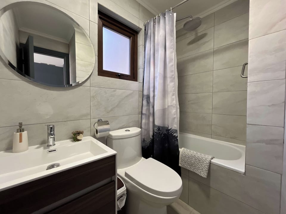 Bathroom with bathtub and round mirror
